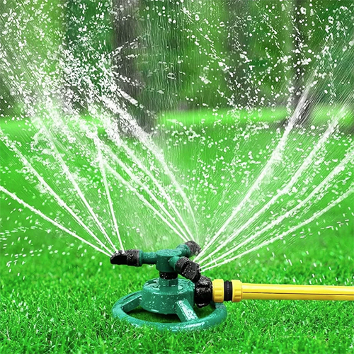 Modern irrigation sprinkler watering a green farm